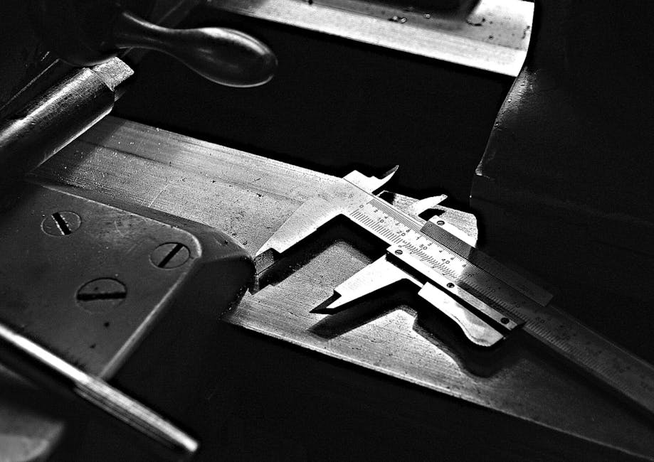A detailed black and white image of a caliper tool on a workshop table, highlighting precision.